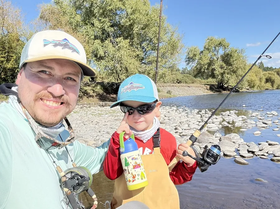Padre e hijo sonriendo junto al río durante el taller Padres e Hijos