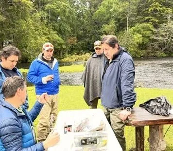 Grupo del taller revisando el equipo sobre la mesa